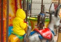 Children ride on the horses on the colorful carousel in the Park Royalty Free Stock Photo