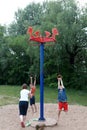 Children on rotating rope swing around central pole