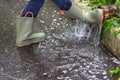 Children rubber boots in an autumn puddle in the rain Royalty Free Stock Photo