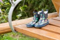 Children rubber boots located on a wooden swing