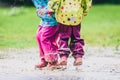 Children in rubber boots and rain clothes jumping in puddle. Royalty Free Stock Photo