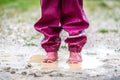 Children in rubber boots and rain clothes jumping in puddle. Royalty Free Stock Photo