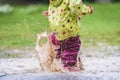 Children in rubber boots and rain clothes jumping in puddle. Royalty Free Stock Photo