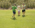 Children run down grassy hill Royalty Free Stock Photo