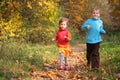 Children run on wood autumn footpath