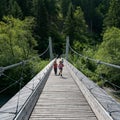 Children running across the suspension bridge over the Rhine river in the Ruinaulta Gorge in the Swiss Alps Royalty Free Stock Photo