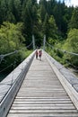 Children running across the suspension bridge over the Rhine river in the Ruinaulta Gorge in the Swiss Alps Royalty Free Stock Photo