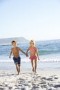 Children running along sandy beach