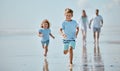Children, running and beach with a brother and sister together on the sand by the sea or ocean during summer. Family Royalty Free Stock Photo