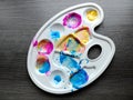 Children`s artists plastic palette with different colors colors on grey background. Concept of art with children, early