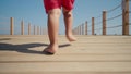 Children's bare feet. Flat feet. Child's bare feet on the wooden bridge.