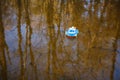 Children`s boat blue goes on the golden water Royalty Free Stock Photo