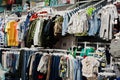 Children`s bright clothes hang on the display in the baby clothing store. Boys section