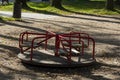 A children`s carousel and an empty playground surrounded by fallen leaves in the autumn in the park Royalty Free Stock Photo