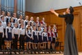 Children`s choir and conductor perform on stage. Royalty Free Stock Photo