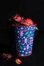 ChildrenÃ¢â¬â¢s Christmas bucket with ornaments filled with red potpourri on black background Royalty Free Stock Photo