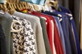 Children`s clothing of different colors hanging on hangers in the store