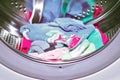 Children`s colored things in the drum of the automatic washing machine, home washing of things