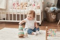 Children`s Day. Sweet funny baby in children room. Scandi style girl room. Child play with educational toys.Early child Royalty Free Stock Photo