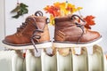 Children`s demi shoes dry on radiator after getting wet Royalty Free Stock Photo