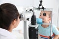 Children`s doctor examining little boy with ophthalmic equipment