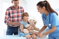 Children`s doctor examining little girl near parent Royalty Free Stock Photo