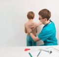 Doctor performs percussion of the lungs and heart in the child at the doctor`s examination., copyspace Royalty Free Stock Photo