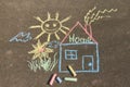 Children`s drawing with chalk on the asphalt: a house with the inscription home , sun and flower Royalty Free Stock Photo