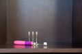 Children`s electric pink toothbrush with backlight with three interchangeable nozzles lies on a dark shelf