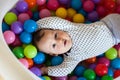 Children`s emotions. Happy baby boy playing with balls Royalty Free Stock Photo