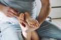 Children`s feet in hands of father. Dad tickles feet of kid sitting on them. Family, having fun at home Royalty Free Stock Photo