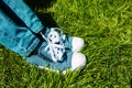 Children`s feet in sneakers and jeans on the green grass Royalty Free Stock Photo