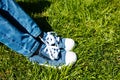 Children`s feet in sneakers and jeans on the green grass