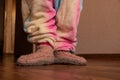 Children`s feet in warm knitted socks on the floor of the house in winter, cold