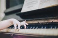 Children`s fingers on the keys of a piano playing.