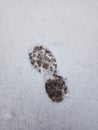 Children`s footprint from a boot on white snow in the winter season.