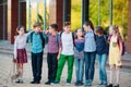 Children`s friendship. Schoolmate students stand in an embrace on the schoolyard.