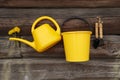Children`s garden toys are carefully hung on the wooden wall with a bouquet of yellow dandelions Royalty Free Stock Photo
