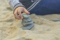 Children`s hand builds a tower of stones on the yellow sand1 Royalty Free Stock Photo