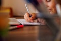 Children's hand close-up. the child uses a pencil to practice writing letters. The child learns to write in a notebook