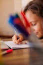 Children's hand close-up. the child uses a pencil to practice writing letters. The child learns to write in a notebook