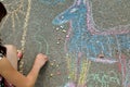 Children`s hand draws with chalk on the pavement