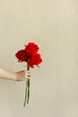 Children`s hand holds a red rose on the beige background and shows like for valentine concept.