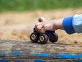 Children`s hand holds a toy. From under the fingers, only the wheels of the car are visible. Royalty Free Stock Photo
