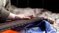 Children`s hand on the neck of an acoustic guitar orange color. learning to play the instrument Royalty Free Stock Photo