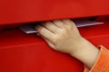Children's hand putting letter in mailbox Royalty Free Stock Photo
