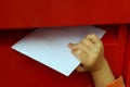 Children's hand putting letter in mailbox Royalty Free Stock Photo
