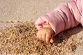 Children`s hand takes a handful of sand