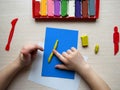 Children's hands with colored plasticine. The child plays and builds figures from play dough. child sculpts from clay