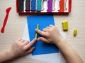 Childrens hands with colored plasticine. Development of fine motor skills of the fingers. The child plays and builds figures Royalty Free Stock Photo